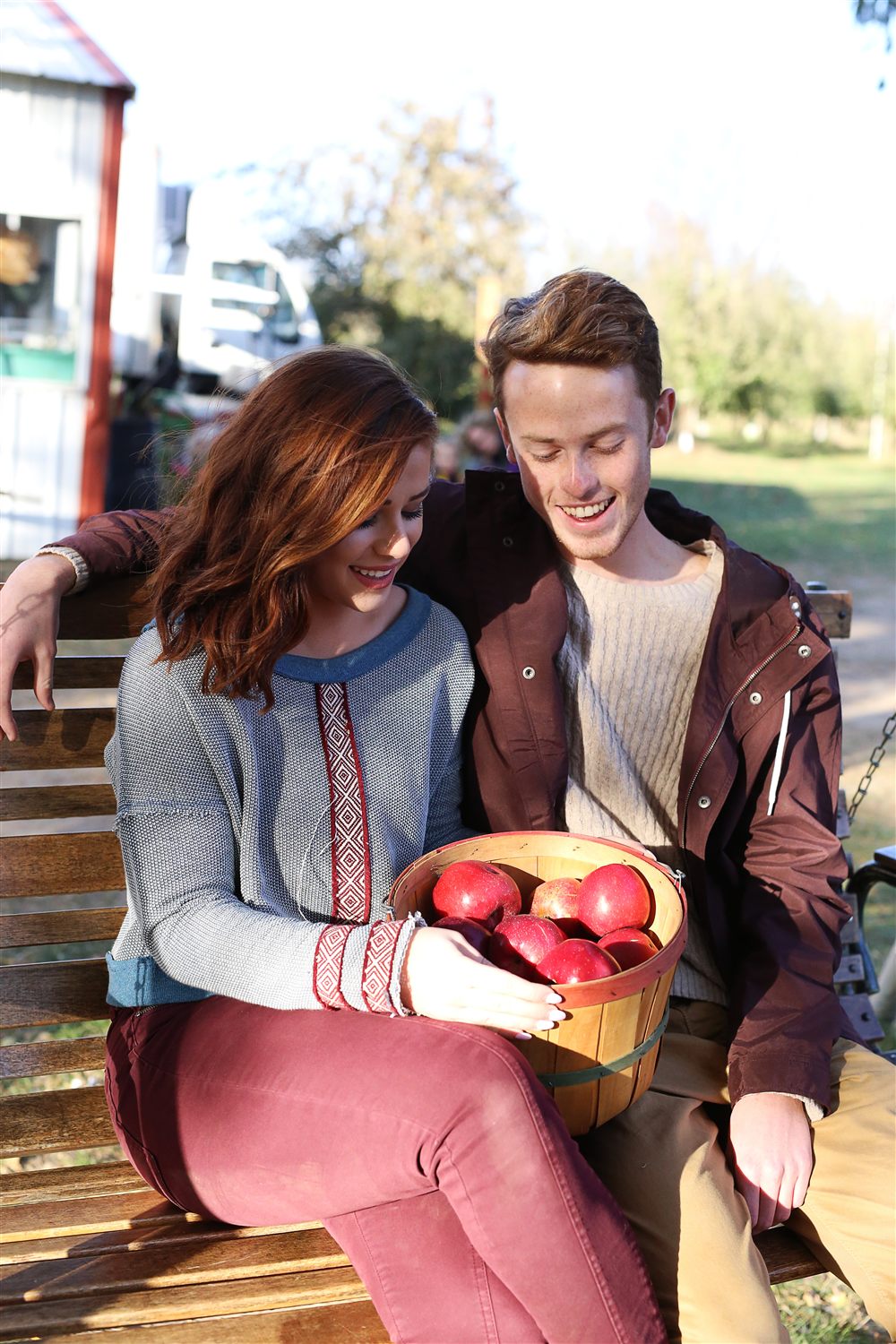 Orchard visitors enjoying a basket filled with freshly picked apples